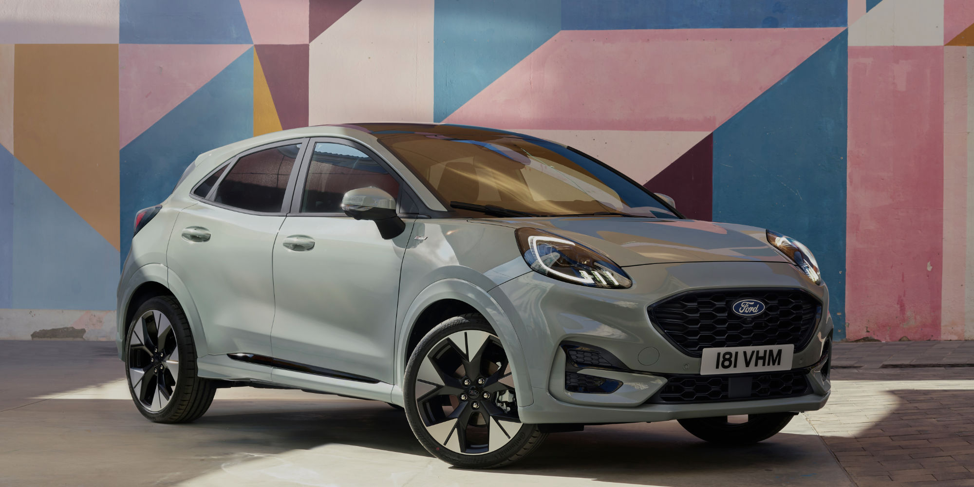 Der neue Ford Puma steht vor einem bunten Hintergrund